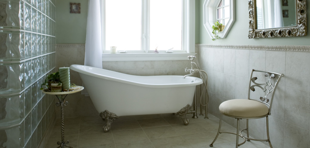 An elegant bathroom with a clawfoot tub. The artwork has been blurred out.